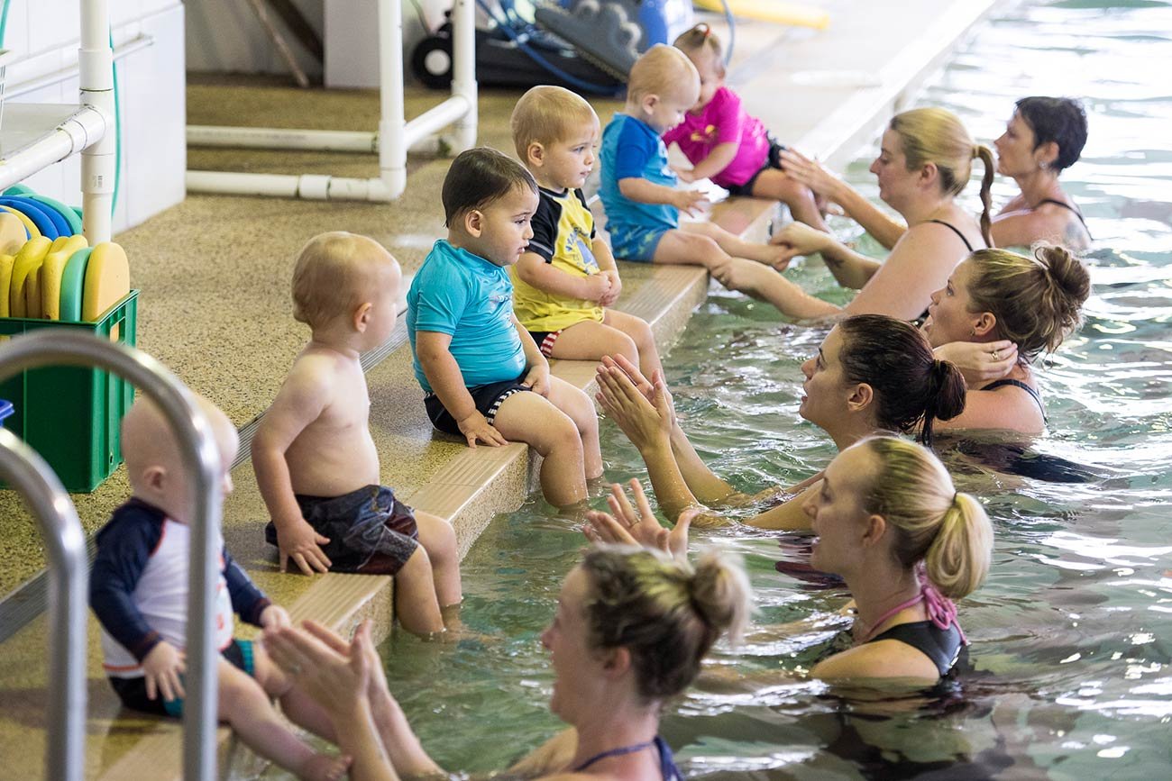 kids learning to swim with their mums